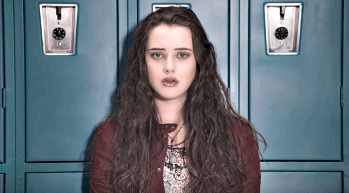 Promotional still from 13 Reasons Why of a scared teenage girl standing in front of high school lockers