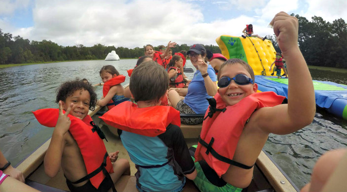 Canoe full of excited campers on a lake