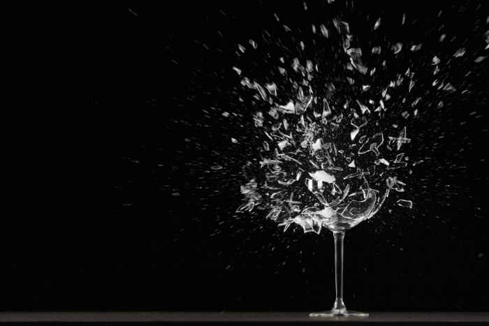 Wine glass exploding against a black background 