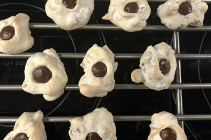 Three rows of small dollops of merengue with a chocolate chip atop each one
