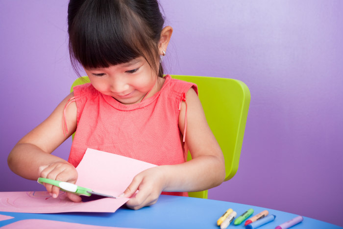 Young girl cutting a piece of foam