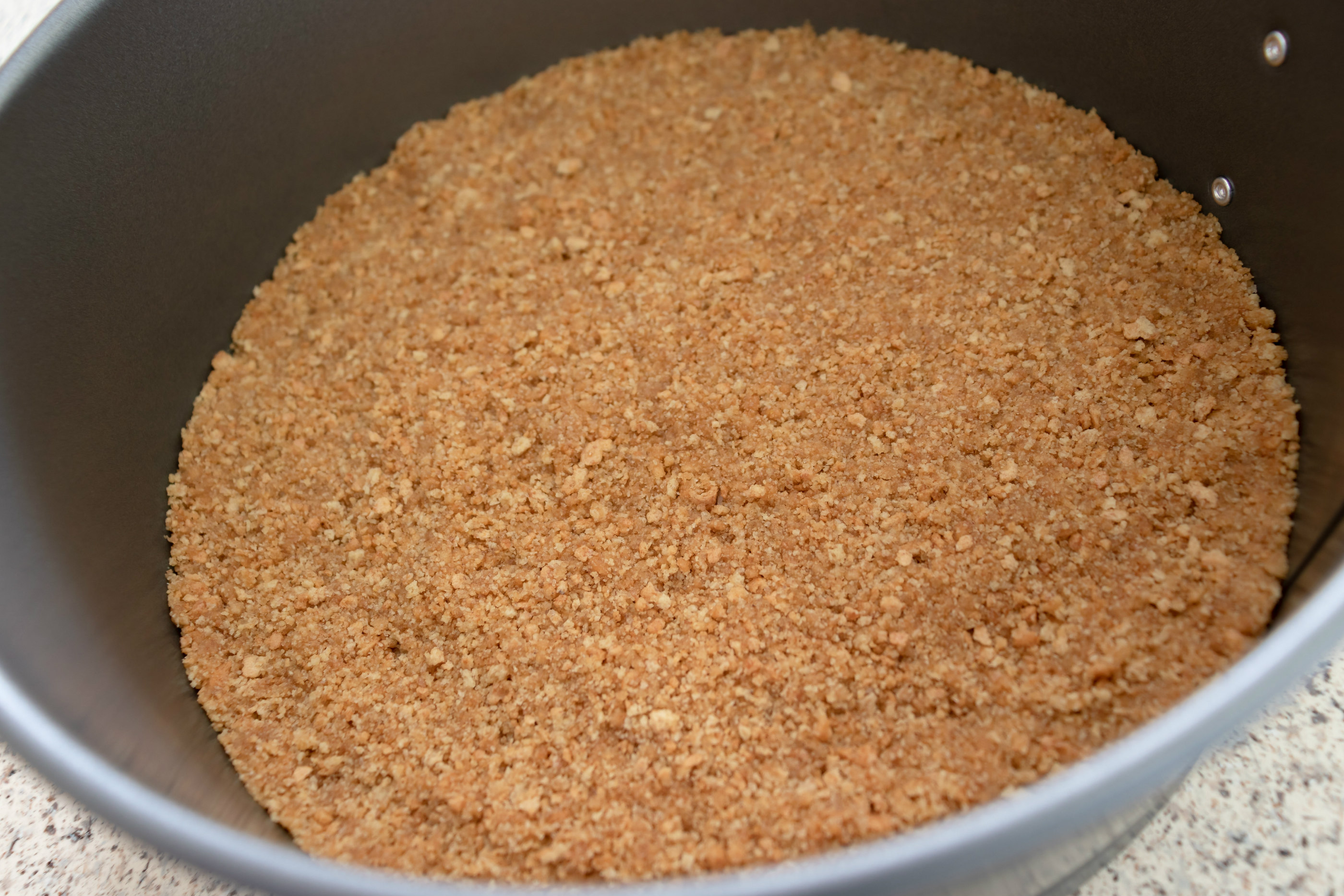 Graham cracker crumbs in a silver bowl