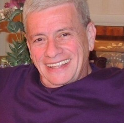 Headshot of Curt Schleier wearing a purple shirt 