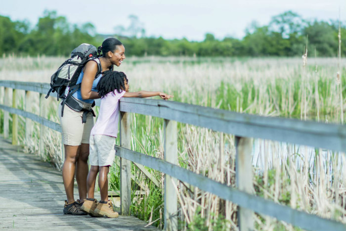 Mother and daughter looking out over a marsh while on a hike