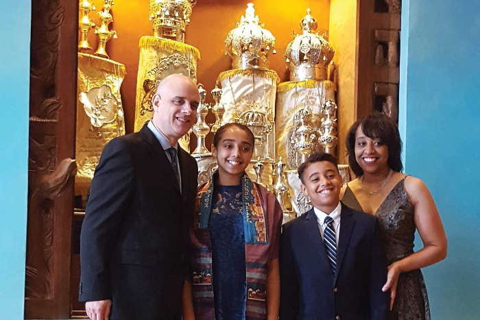 Gina Drangel with her husband and two children dressed up and standing in front of an open ark