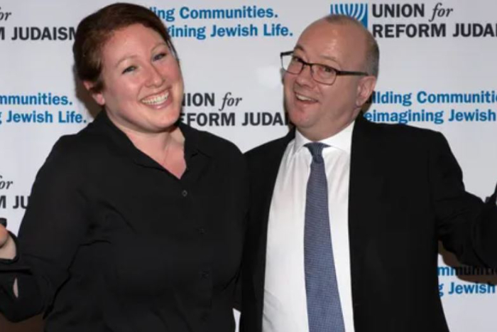 Katie Klein and TJ Shanoff posing together in front of a URJ Biennial banner