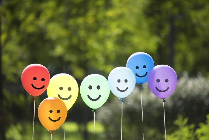 smiles drawn on balloons in an assortment of colors