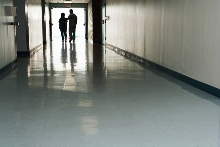 two people standing in a hallway in a hospital