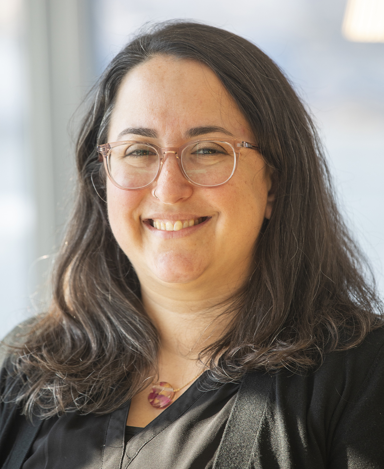 An image of Rabbi Jen Gubitz - a person with shoulder length brown hair and glasses