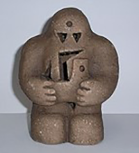 Figurine of short, squat humanoid, with opened chest area, triangle eyes, and circle on the forehead.