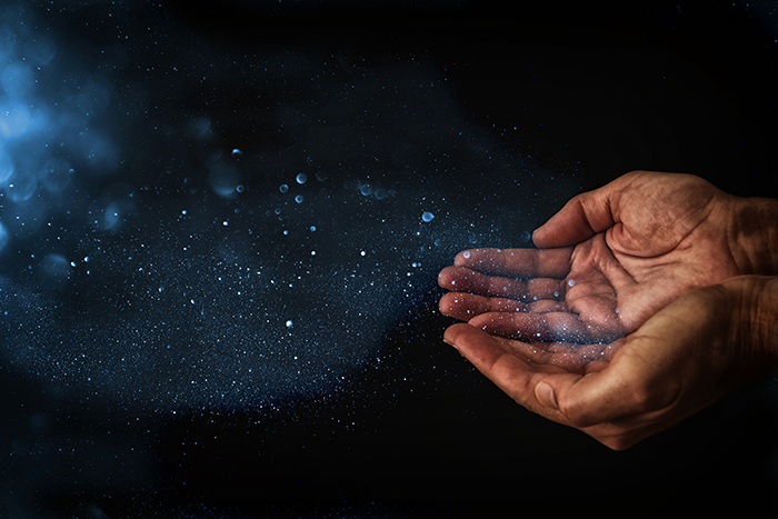 an image of dust flying out of two cupped hands