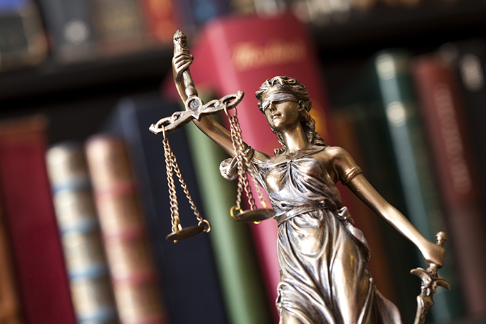 an image of a bronze statue of a woman blindfolded holding the scales of justice