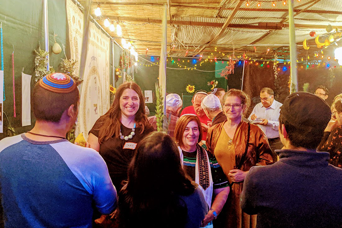 an image of a group of people standing under a sukkah