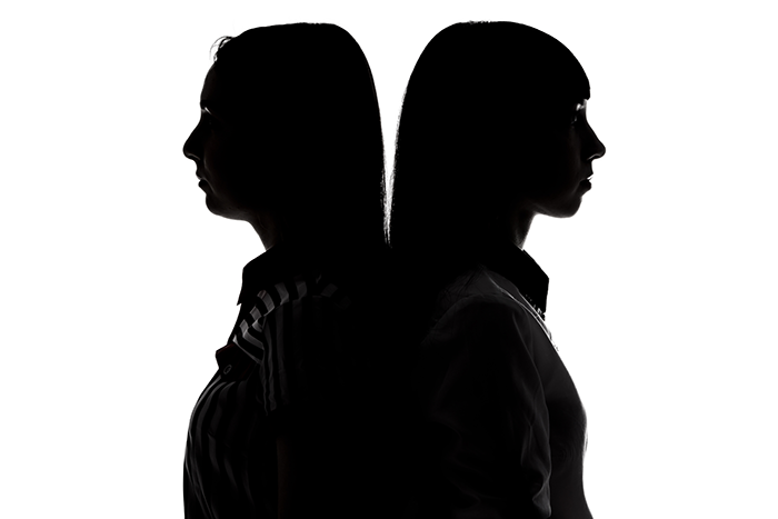 an image of two woman, standing back to back as if they are shadows of each other; both staded black on white background