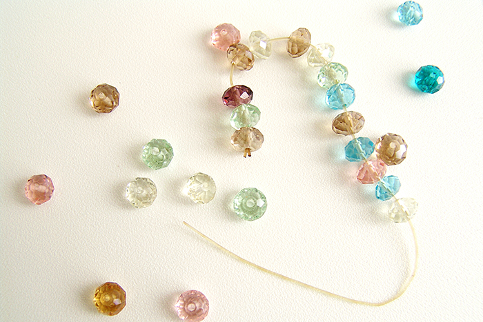 Photo of colorful beads; some on a string and some next to it