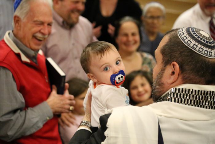 A rabbi holding a baby