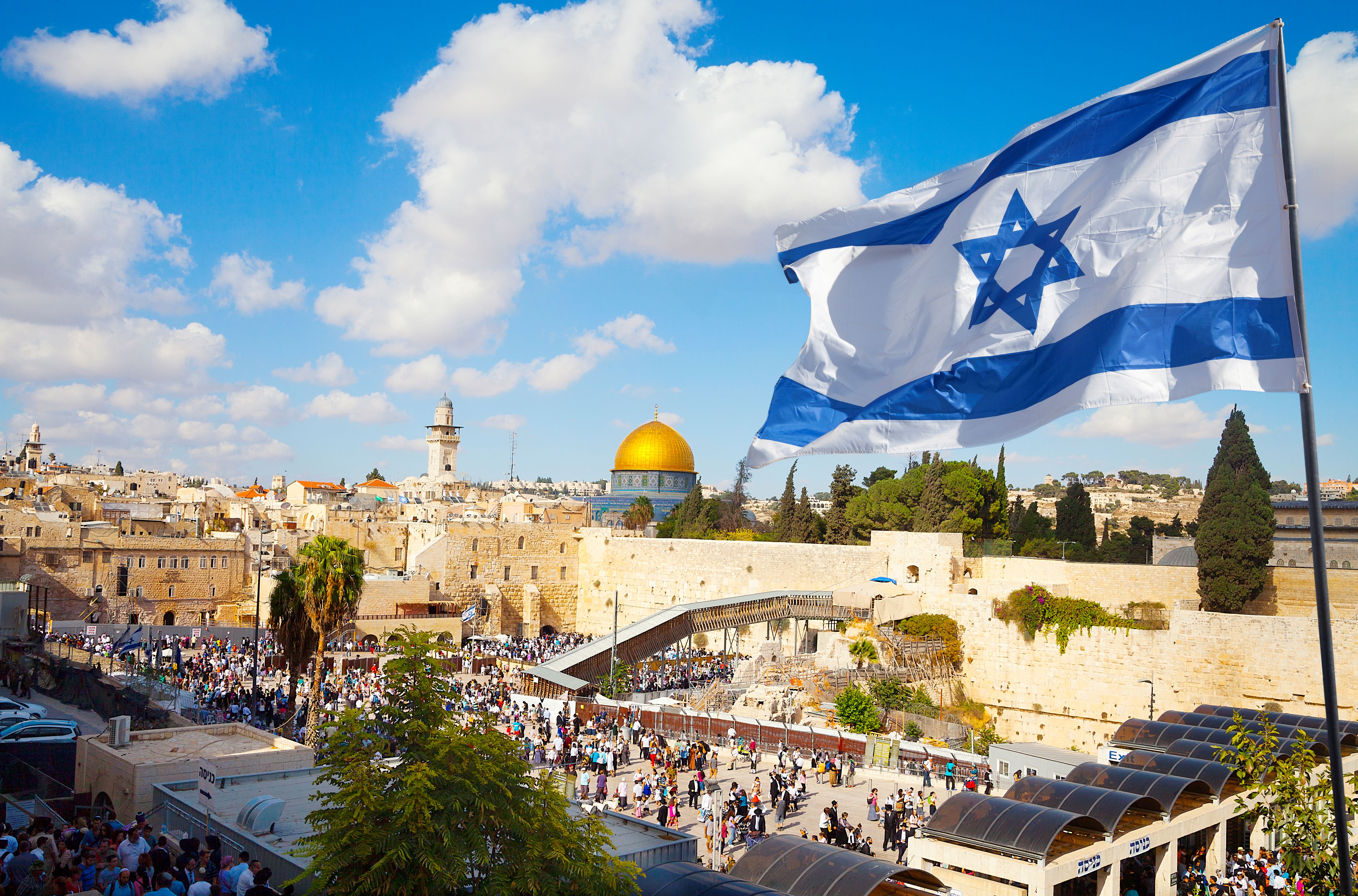 A view of the Western Wall with an Israeli flag blowing in the wind