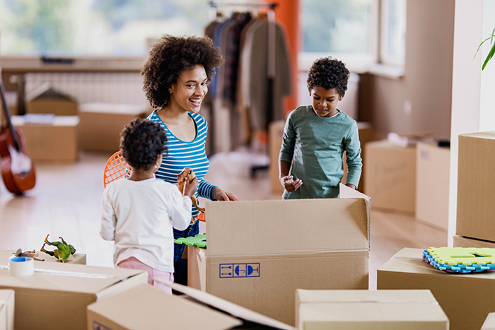 Photo of a mother and two kids uppacking boxes