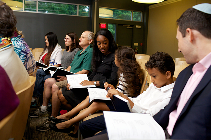 Photo of people sitting in services with open prayer books