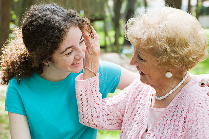 Photo of an elderly woman embracing her young granddaughter