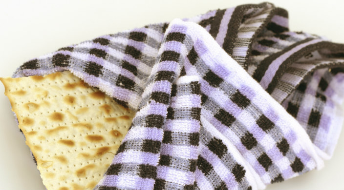Piece of broken matzah wrapped in a purple checkered cloth 