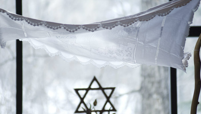 Closeup of a lace chuppah with a Star of David beneath it