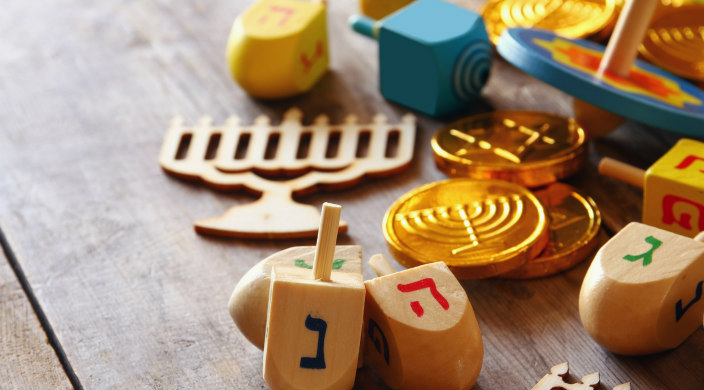 Flatlay of gelt dreidels and woodcut hannukiyot 