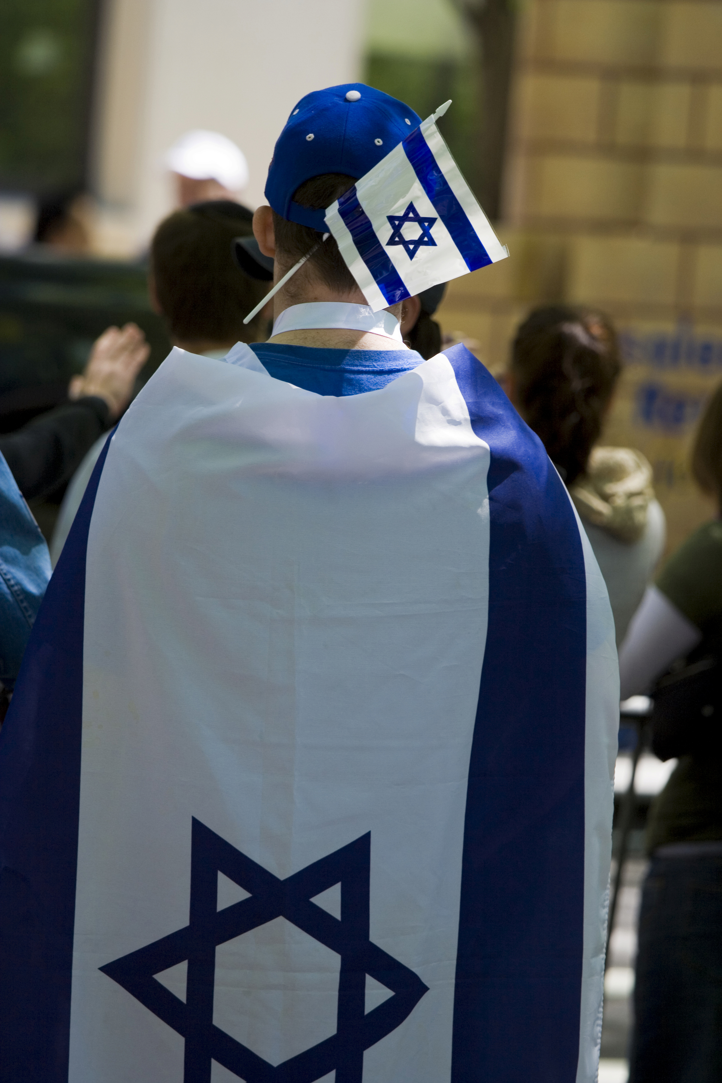 A young boy wearing an Israeli flag as a cape