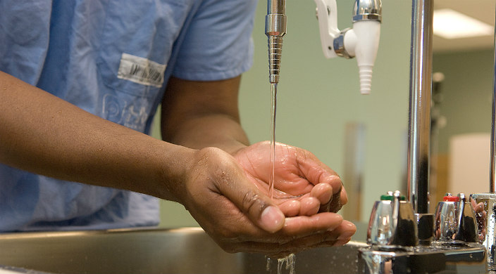 Person washing hands at a hospital/surgical sink