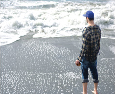 young man contemplating life by the sea during the Jewish High Holidays