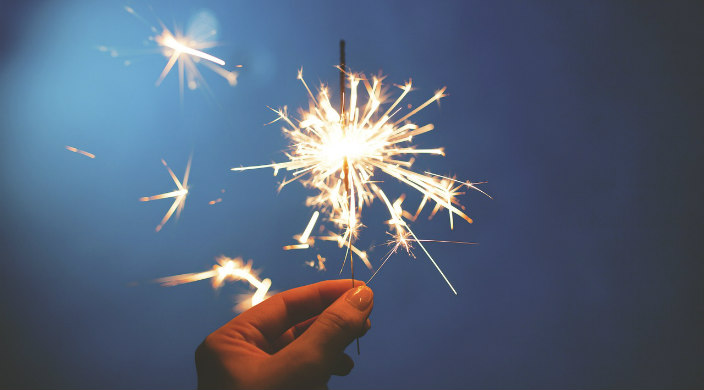 Closeup of a hand holder a sparkler at twilight 