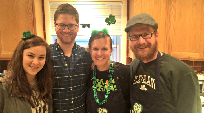 Two couples smiling into the camera while wearing green St Patricks Day attire