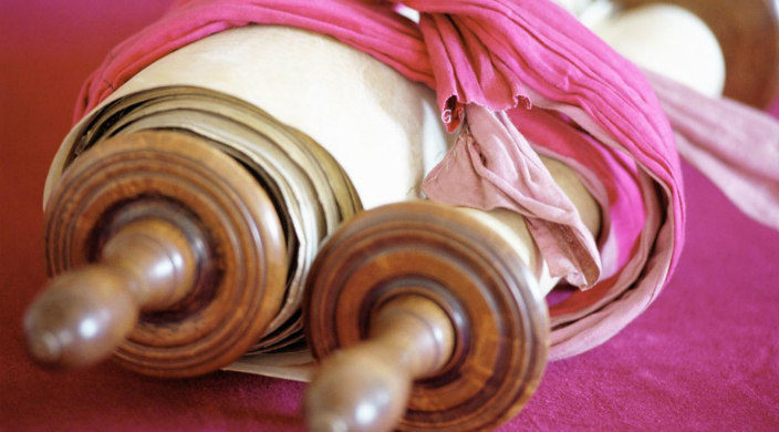 Torah scrolls wrapped with pink fabric ties 
