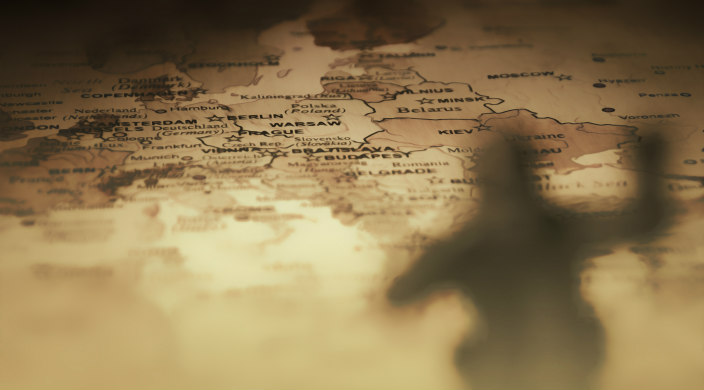 Shadow of sepia-tone WWI soldier against a background of a map of Europe