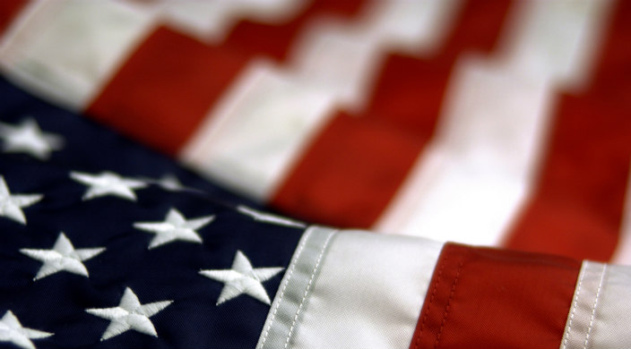 Close up on American flag; stars in the foreground, stripes in the background