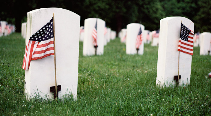Gravestones with American flags in front of each one