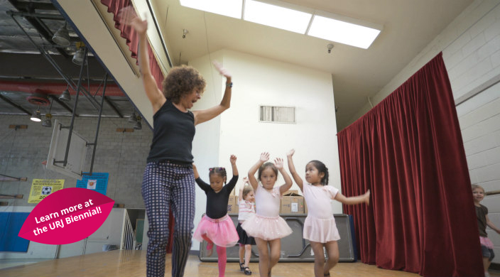 An older woman instructing preschool ballet students