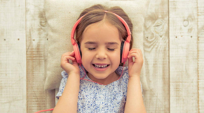 Young girl smiling with eyes closed and headphones on