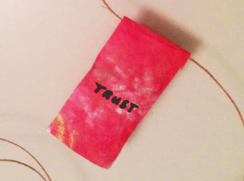 Pink banner on string that says trust on it