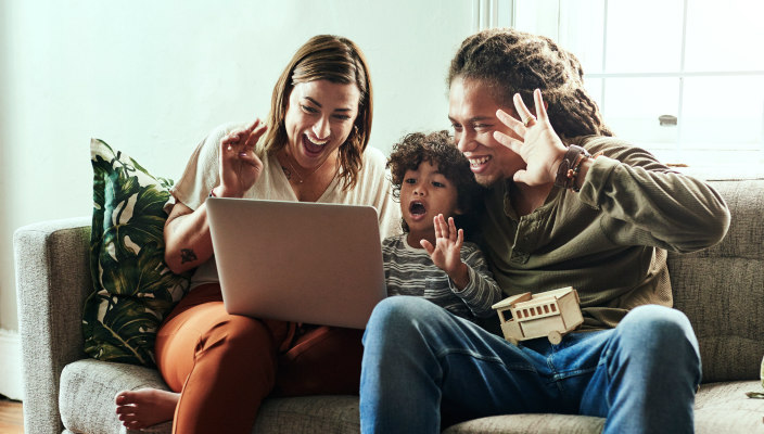 Multi-racial family gathered enthusiastically around a computer