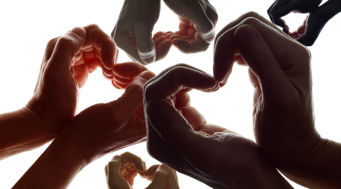 Many pairs of hands forming hearts