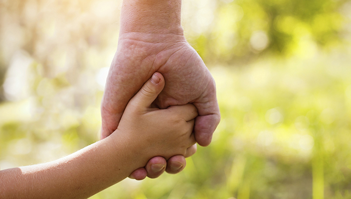 adult and child holding hands