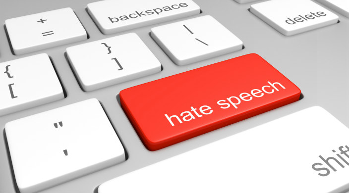 Computer keyboard; the return key is red and says hate speech on it