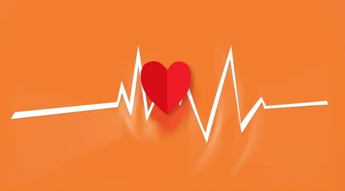 Red paper heart against an orange background with a white line through it like an echo cardiogram