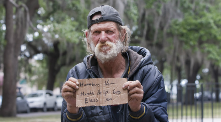 Homeless man with cardboard sign