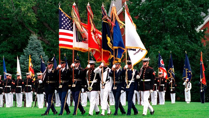 members of the Armed Forces holding their respective flags