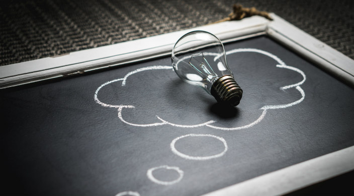 Lightbulb on small chalkboard surrounding by a speech bubble