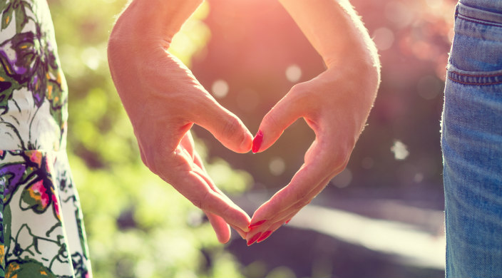 Bride and groom forming heart with their hands