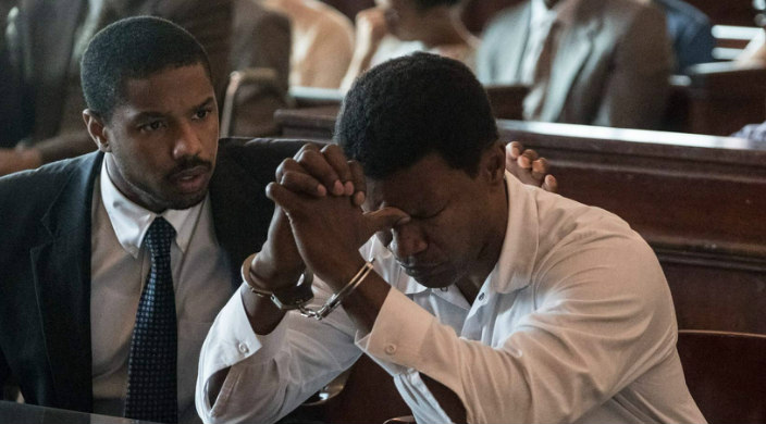 Still from the film Just Mercy showing Michael B Jordans character comforting the character played by Jamie Foxx