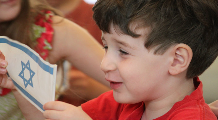 Young boy holding Israeli flag 